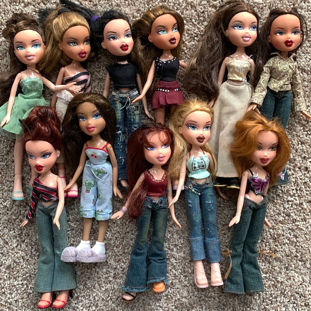 Set of 11 Bratz dolls with clothes. Case included.